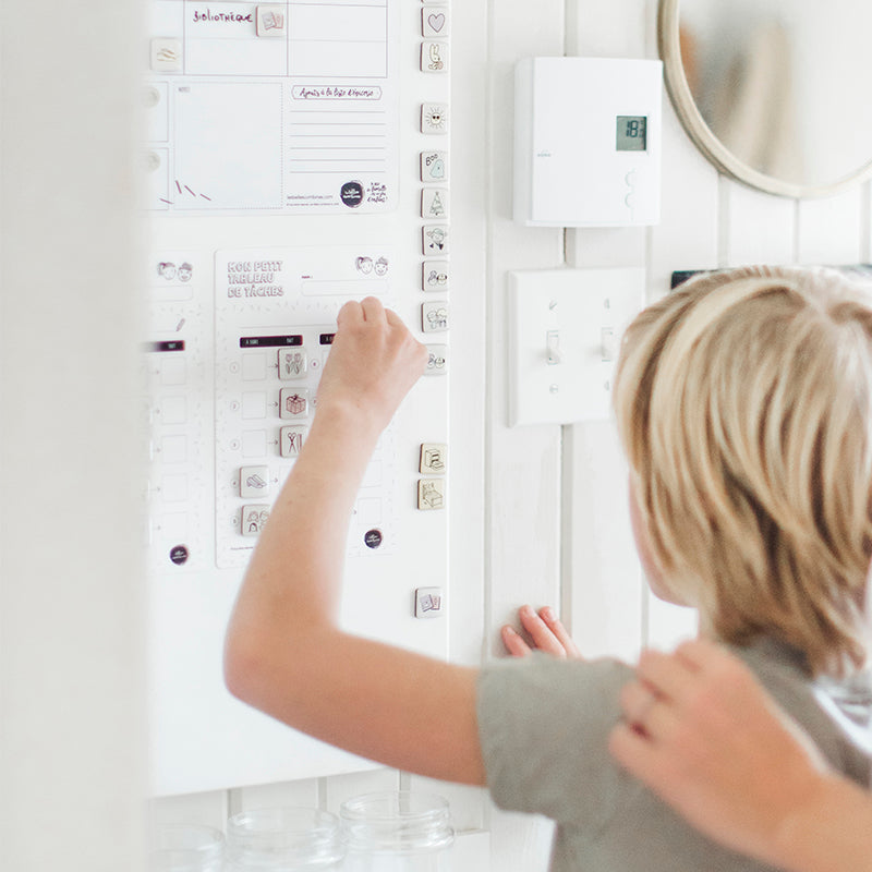 Enfant qui déplace un magn.to sur le petit tableau de tâches Les Belles Combines